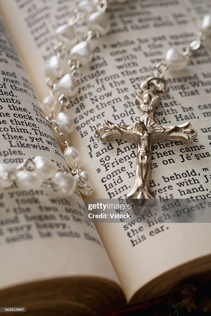 Close-up of open Bible and pearl rosary beads