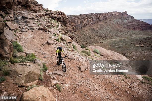 a man biking on slickrock trails. - desertman stock pictures, royalty-free photos & images
