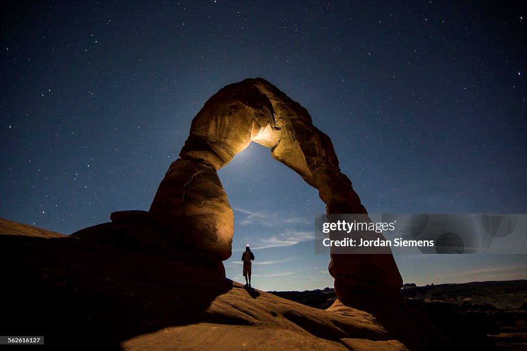 A hiker standing underneath an arch.