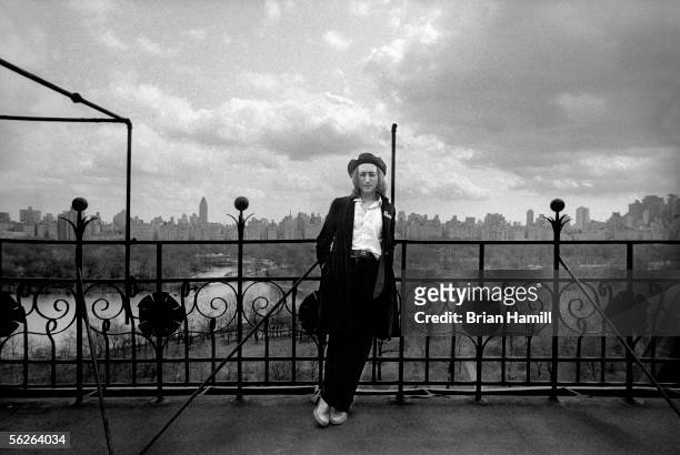 British-born singer and songwriter John Lennon leans on a railing which overlooks Central Park and the Manhattan cityscape on the roof of his...