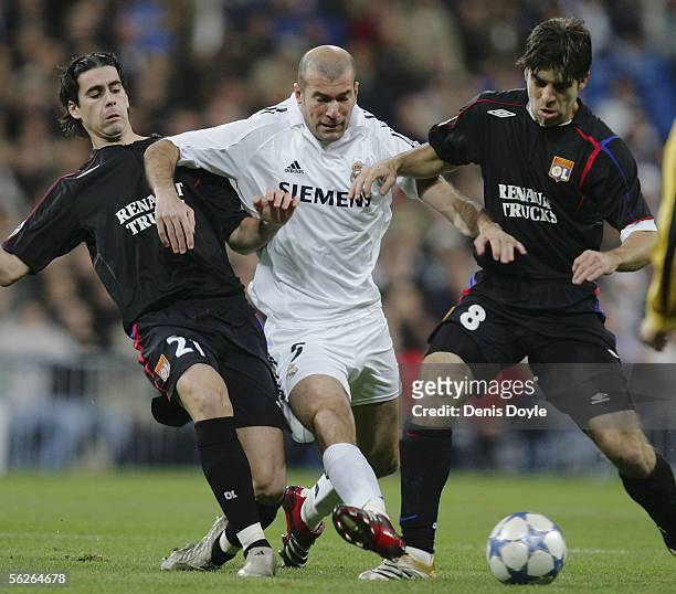 Zinedine Zidane of Real Madrid is tackled by Mendes Tiago and Pernambucano Juninho of Lyon during the UEFA Champions League group F, match between...