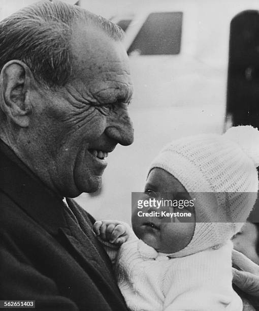 Prince Frederick of Denmark holding his granddaughter Princess Alexia of Greece as they arrive in Copenhagen, November 2nd 1965.