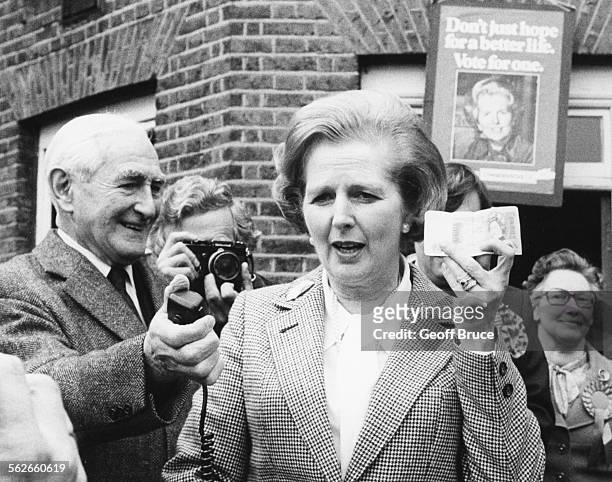 Conservative Party leader Margaret Thatcher holding up a one pound note to the press, to illustrate the devaluation and inflation of the note, as she...