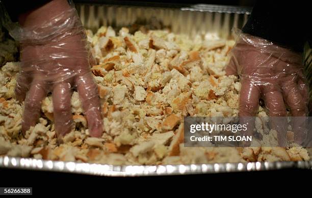 Washington, UNITED STATES: A young man mixes bread crumbs for stuffing as volunteers prepare some of the 5,000 Thanksgiving dinners during the annual...