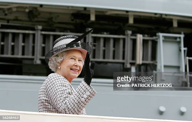 Britain's Queen Elizabeth II waves from the gangway of the British Royal Navy aircraft carrier "HMS Illustrius" in Valletta's main harbour in Malta,...