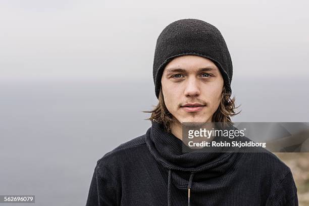 portrait of young man with long hair and hat - 20 24 anni foto e immagini stock