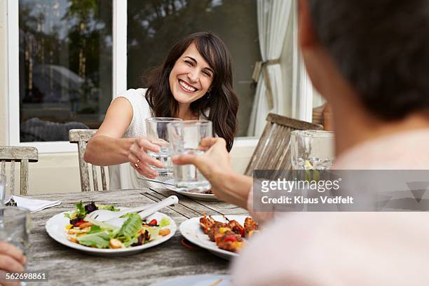 women toasting at oustide dinner on terrace - woman eating toast stock pictures, royalty-free photos & images