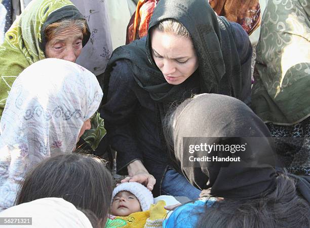 In this handout photo from United Nations Humanitarian Commitee of Refugees, Goodwill Ambassador Angelina Jolie talks with women who survived the...