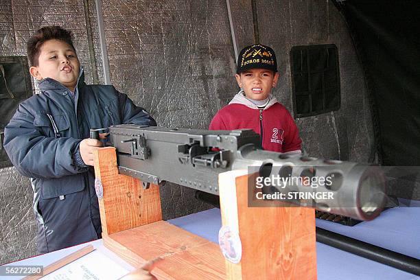 Turkish Cypriot boys play with heavy machine guns in the exhibition area during the Toros 2005 military exercise in the Turkish part of Cyprus 25...