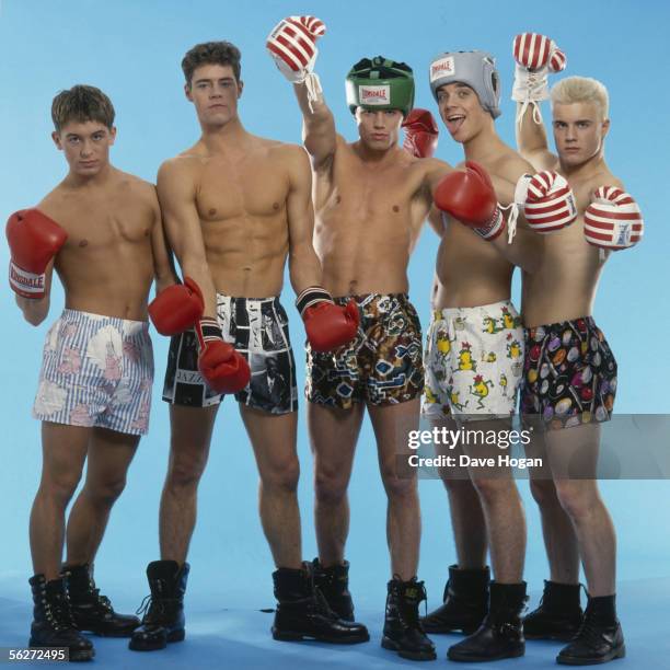 English boy band Take That pose in combat boots, boxer shorts and red boxing gloves, as worn in their first video 'Do What You Like', 1991. From left...