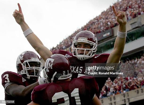 Quarterback Stephen McGee of the Texas A&M Aggies celebrates his third quarter touchdown with Brandon Leone and Martellus Bennett during play against...
