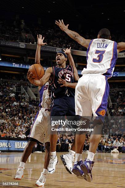 Vince Carter of the New Jersey Nets shoots past the block of Boris Diaw and Raja Bell of the Phoenix Suns on November 25 at America West Arena in...