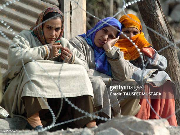 Kashmiri women sit behind a barrier of barbed wire as they listen to Indian President A.P.J Abdul Kalam make a speech to earthquake survivors during...