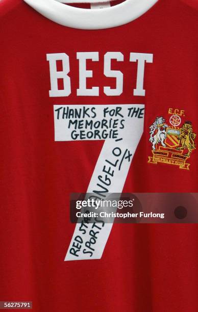 Number seven shirt hangs on railings as hundreds of football fans lay flowers in memory of football legend George Best outside Old Trafford the home...