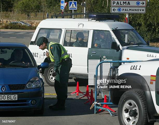 Palma de Mallorca, SPAIN: A Spanish Civil Guard checks 26 November 2005 a car at the entrance of the building where the first Alliance of...