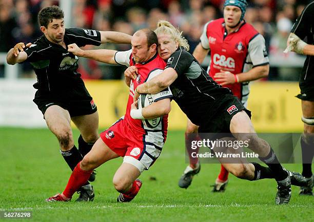 Ludovic Mercier of Gloucester is tackled by Dave Seymour of Saracens during the Guinness Premiership match between Gloucester Rugby and Saracens at...