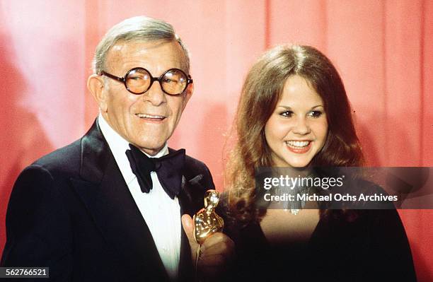 Actor George Burns with actress Linda Blair poses backstage after winning " Best Supporting Actor" award during the 48th Academy Awards at Dorothy...