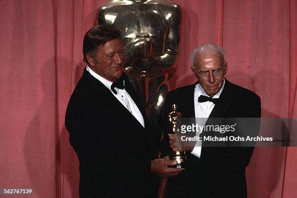 Actor John Wayne and Director Howard Hawks, Academy Honorary Award winner pose backstage during the 47th Academy Awards at Dorothy Chandler Pavilion...