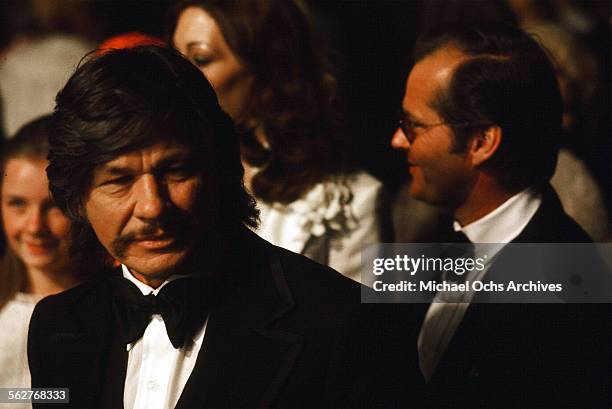 Actor Charles Bronson arrives along with Jack Nicholson and actress Anjelica Huston to the 48th Academy Awards at Dorothy Chandler Pavilion in Los...