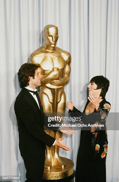 Actor John Travolta and actress and host Liza Minnelli pose backstage during the 55th Academy Awards at Dorothy Chandler Pavilion, Los Angeles,...