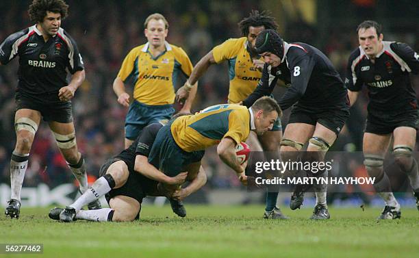 Cardiff, UNITED KINGDOM: Australia's Chris Latham is tackled by a Welsh forward during the match on 26 November at the Millennium Stadium, Cardiff,...