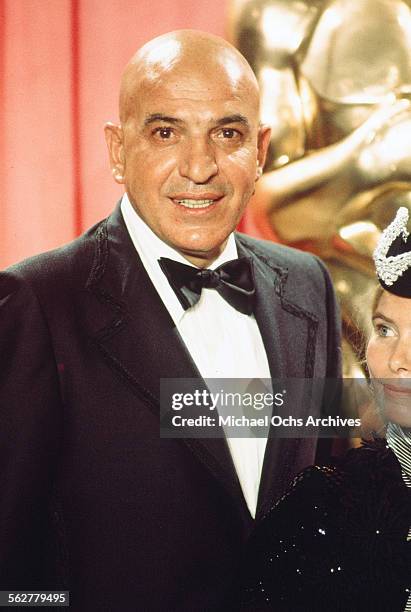 Actor Telly Savalas poses backstage with Ulla-Britt Soderlund winner of "Best Costume Design" award during the 48th Academy Awards at Dorothy...