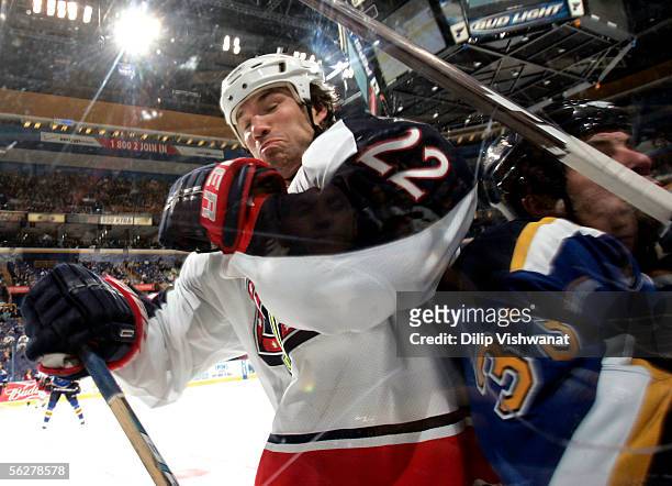 Luke Richardson of the Columbus Blue Jackets checks Eric Boguniecki of the St. Louis Blues into the boards at Savvis Center on November 26, 2005 in...