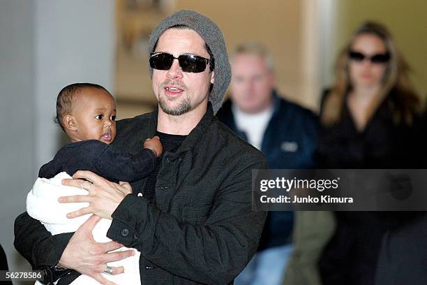 Actor Brad Pitt followed by actress Angela Jolie holds Zahara Marley Jolie as they arrive at the New Tokyo International Airport on November 27, 2005...