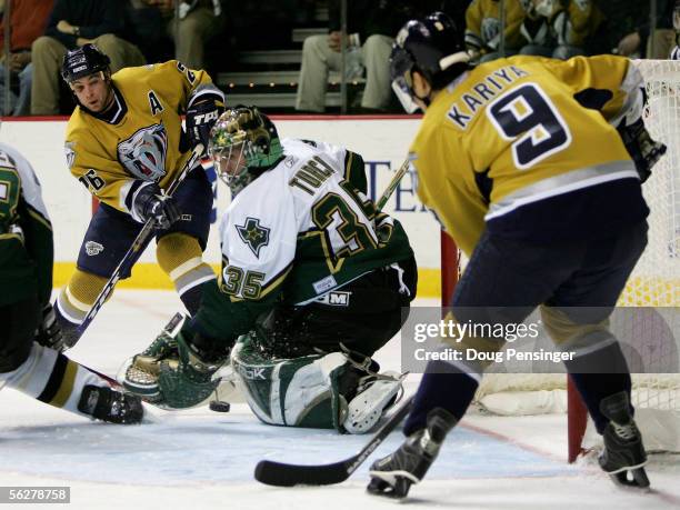 Goaltender Marty Turco of the Dallas Stars collects the puck as Steve Sullivan and Paul Kariya of the Nashville Predators put pressure on the goal as...