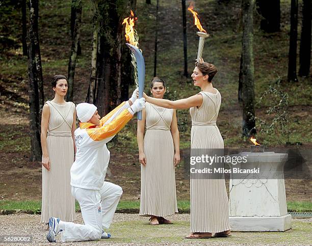 Greek athlete Costas Fillipidis, the first torchbearer, recives the flame from ActressTheodora Siarkou, who plays the role of high priestess, during...