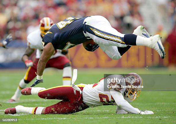 Fullback Lorenzo Neal of the San Diego Chargers is upended by Carlos Rogers of the Washington Redskins during the first half of the game on November...
