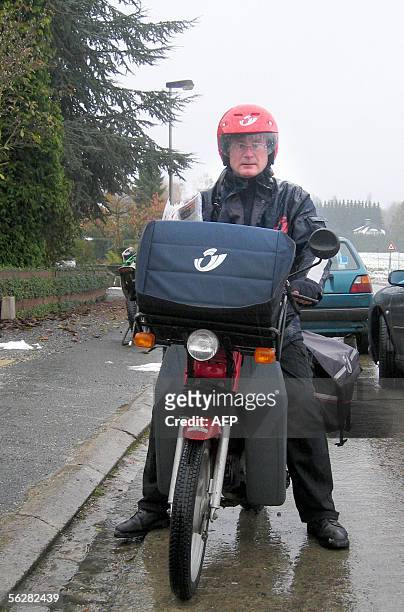 Belgian postman poses with his motorcyle and his helmet 28 November 2005 in Wavre. The ever-efficient Belgian postal service wants to know how long...