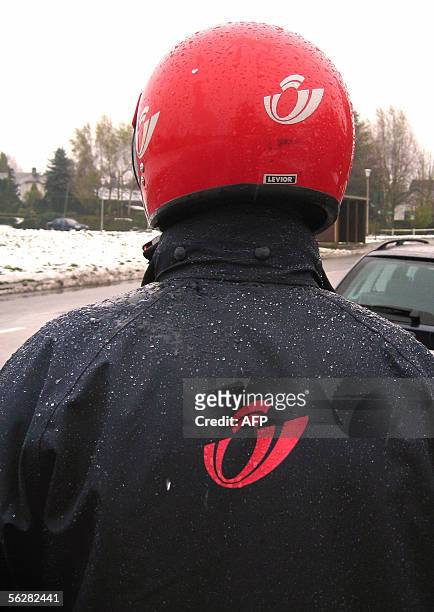 Belgian postman poses with his helmet 28 November 2005 in Wavre. The ever-efficient Belgian postal service wants to know how long it takes mailmen...