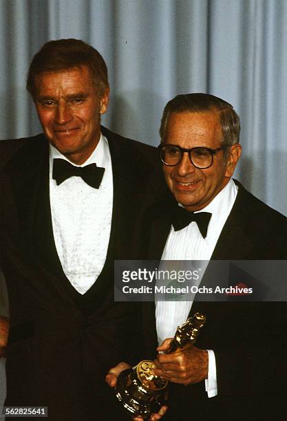 Actor Charlton Heston pose backstage with Walter Mirisch who receives the "Jean Hersholt Humanitarian Award" during the 55th Academy Awards at...