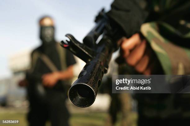 Masked Palestinian gunmen stand out side a polling station for Fatah movement after they closed it, November 28, 2005 at the Khan younis camp in...