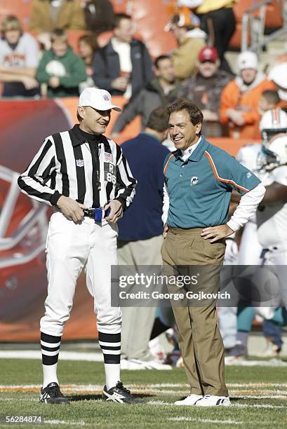 Head coach Nick Saban of the Miami Dolphins smiles while talking to referee Bernie Kukar before a game against the Cleveland Browns at Cleveland...