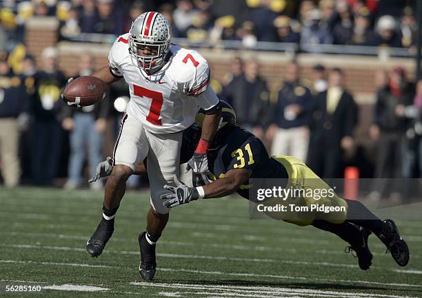 Ted Ginn Jr. #7 of the Ohio State Buckeyes tries to evade a tackle by Brandent Englemon of the Michigan Wolverines during the NCAA game at Michigan...