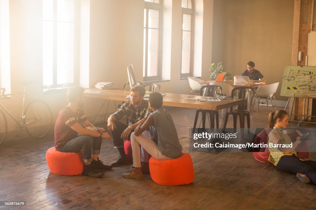 Casual business people meeting in circle in sunny office