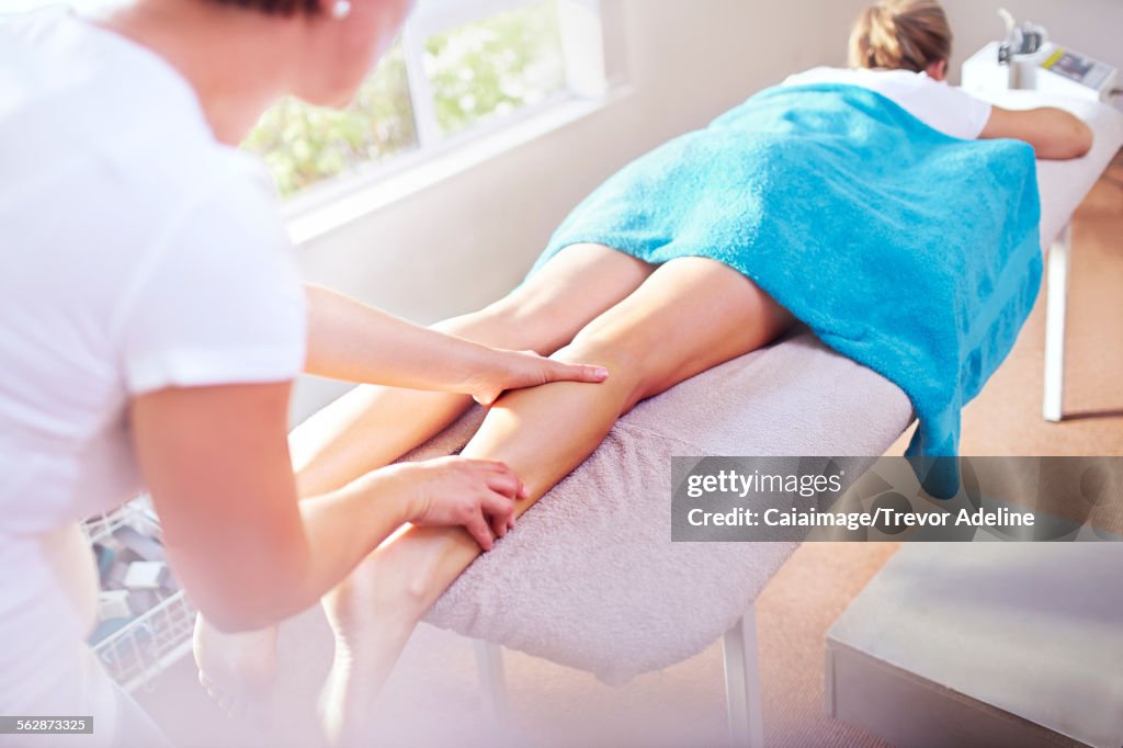 Masseuse massaging womans leg