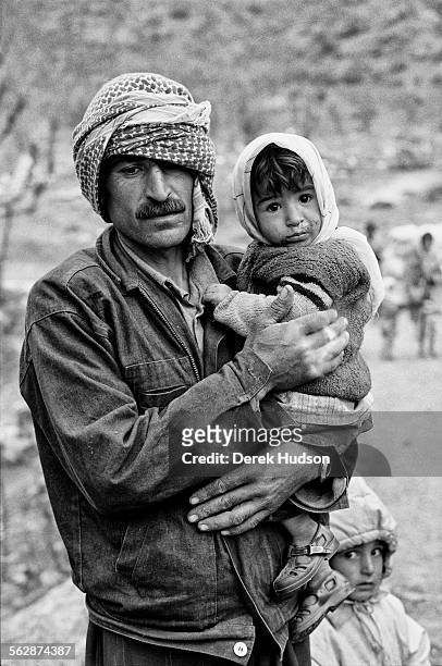 Holding his baby girl child a Kurdish man and his son on the road towards the camp site at Isikveren, Turkey where thousands of Kurds landed up after...