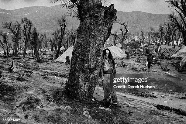 Lost in despair, a Kurdish man shelters from the welcome rains they melted the frozen ground at their makeshift camp near the town of Isikveren,...