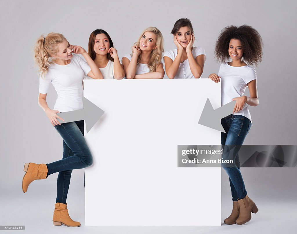 Multi-ethnic women with empty billboard. Debica, Poland