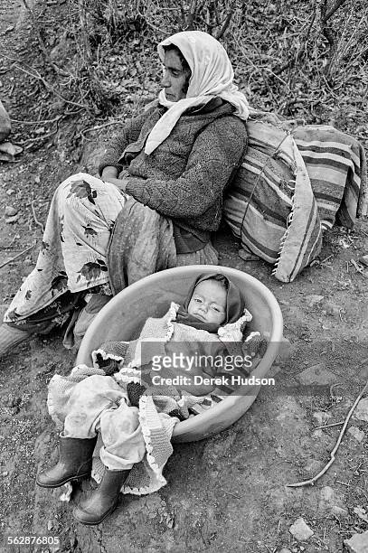 Resting from carrying her daughter in a plastic tub down a mountainous path towards the makeshift camp near the town of Isikveren, Turkey. The Iraqi...