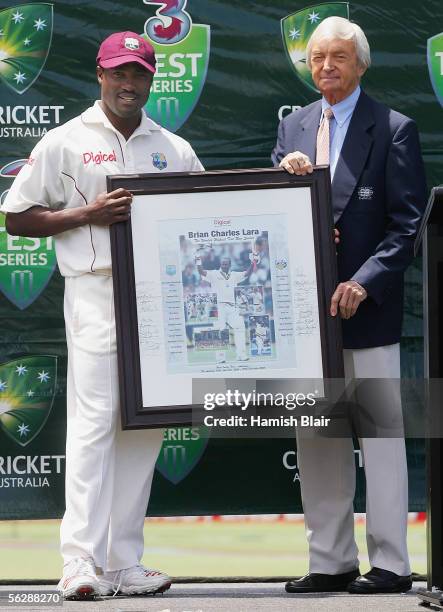 Brian Lara of the West Indies is presented with a photograph commemorating his world record Test run tally by commentator and former Australian...