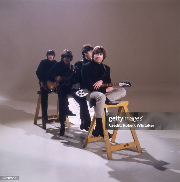 The Beatles, left to right: John Lennon , Paul McCartney, George Harrison and Ringo Starr sitting on a trestle during the making of a promotional...