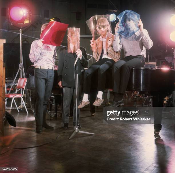 The Beatles, left to right, John Lennon, Ringo Starr, George Harrison and Paul McCartney, posing with coloured cells over their faces during the...