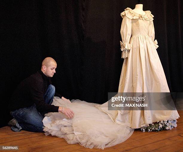 London, UNITED KINGDOM: A duplicate dress, weared by Princess Diana for her wedding with Prince Charles 29 July 1981, is displayed by an employee of...