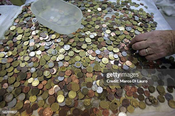 Caritas Employee process coins from the Trevi Fountains November 28, 2005 in Rome, Italy. Tourists from all over the world come to Rome's Trevi...