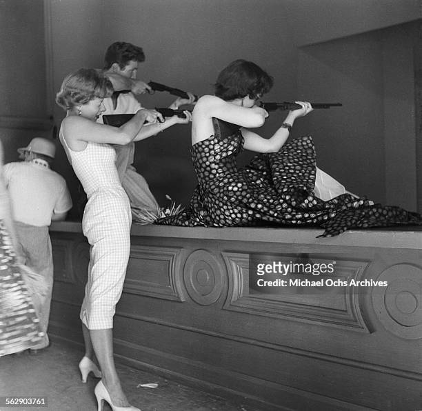 Actor Steve Rowland and actress Kathleen Case and Adelle August pose as they play arcade games during the Opening day of Disneyland in...