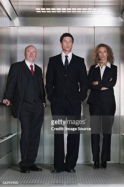 business people in a lift - vantarsi foto e immagini stock